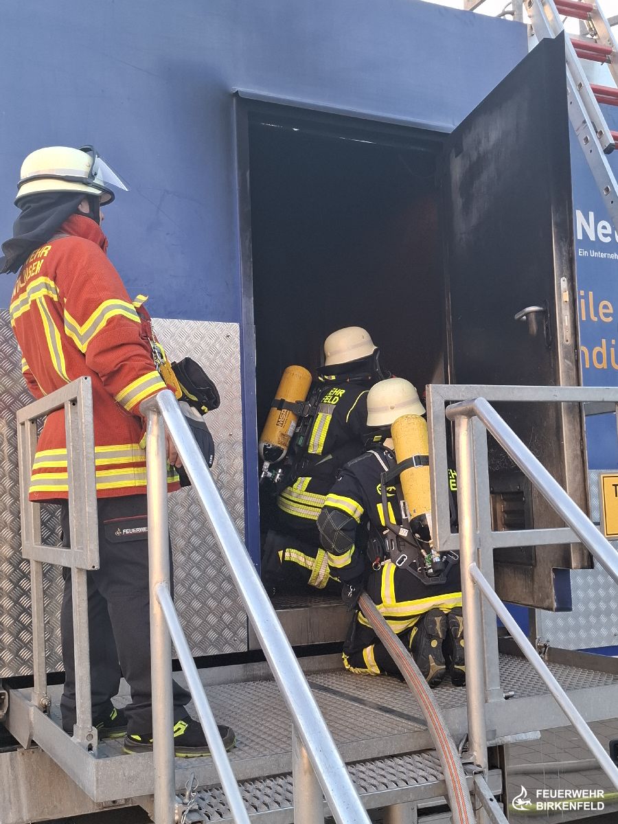 Trupp vor Brandcontainer mit Ausbilder