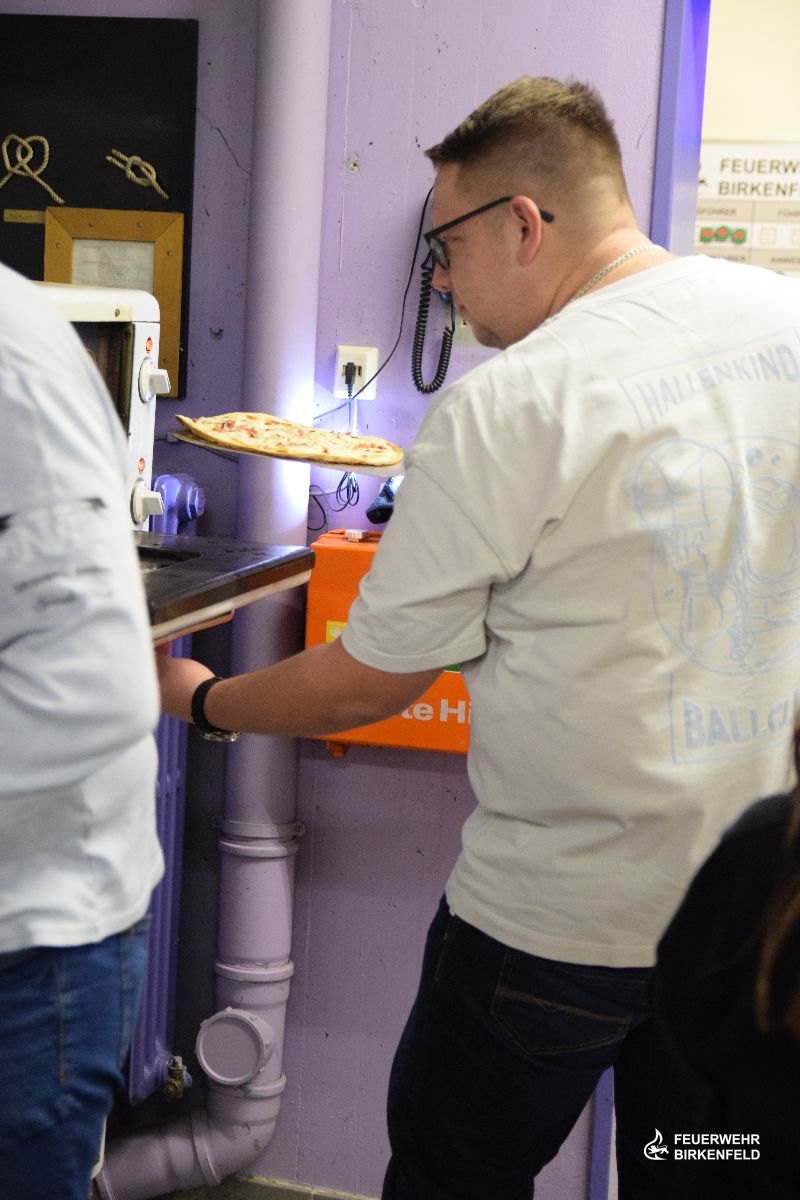 Kamerad schiebt Flammkuchen in Ofen