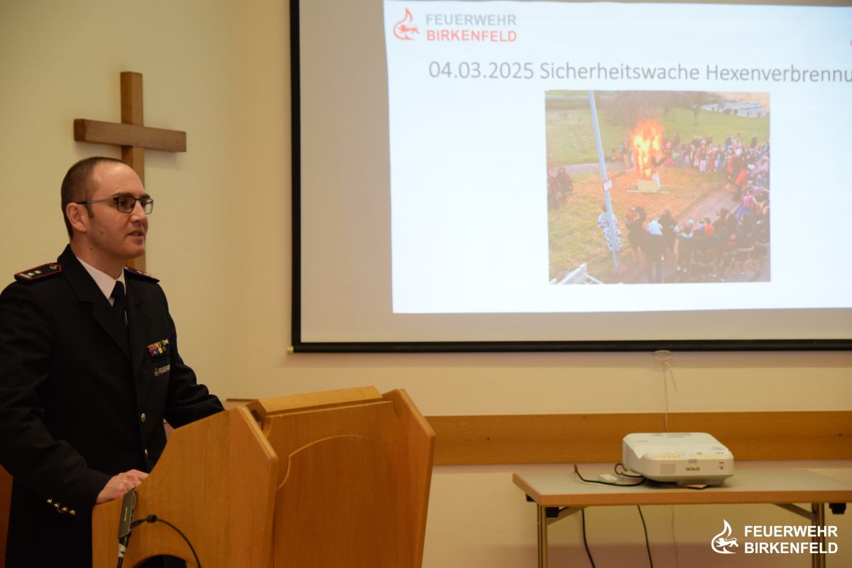 Jakob Bauser am Rednerpult mit Beamer-Bild im Hintergrund