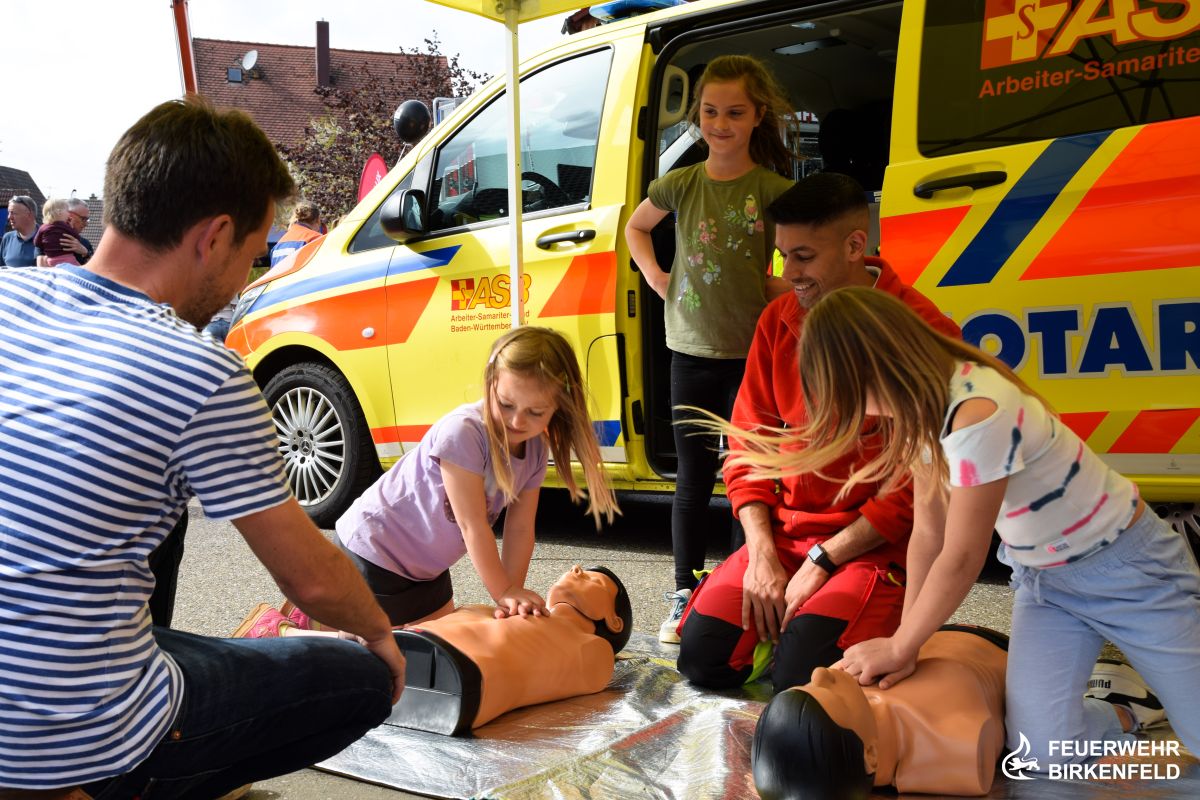 Kinder bekommen Reanimation anhand Übungspuppe gezeigt
