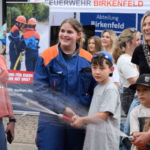 Personen halten lachend Strahlrohr