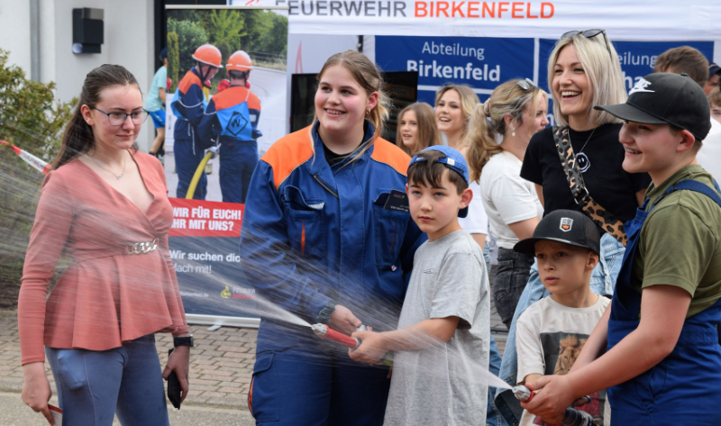 Personen halten lachend Strahlrohr